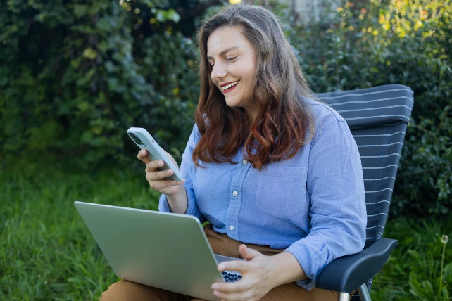 Billeder der sidder i haven med en computer